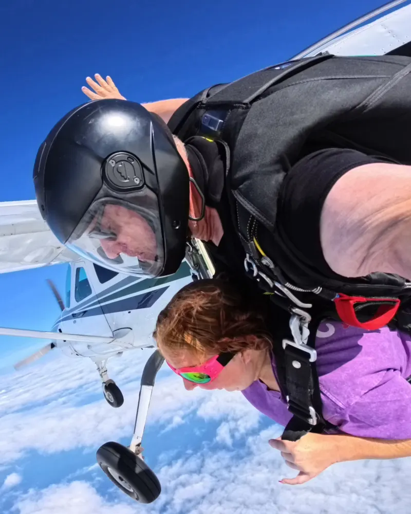 Tandem skydivers in freefall beside the jump plane