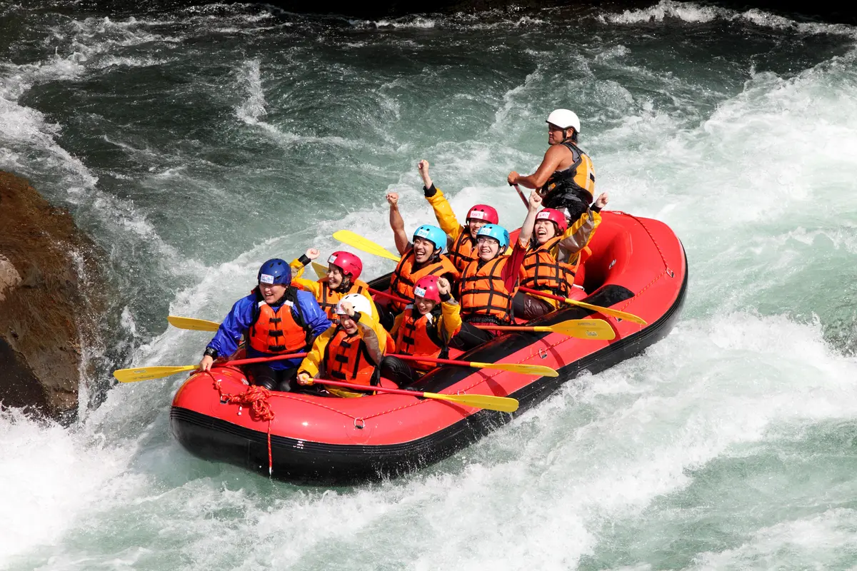Raft crew paddling through whitewater
